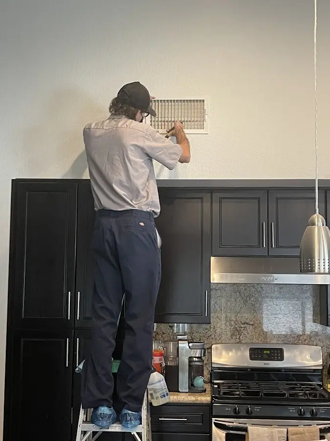 Technician inspecting an air vent during HVAC service in Vero Lake Estates